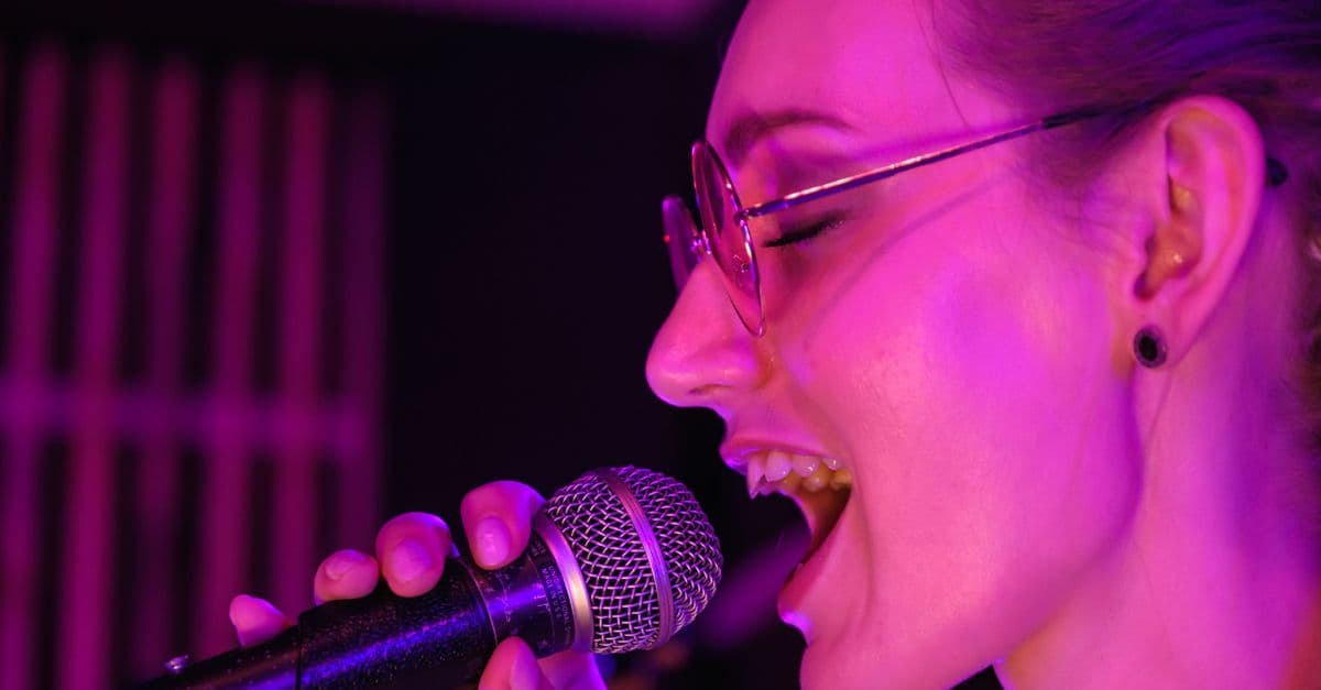 Pessoa cantando ao microfone — Músicas de Natal em inglês pra fechar o ano letivo com clima natalino
