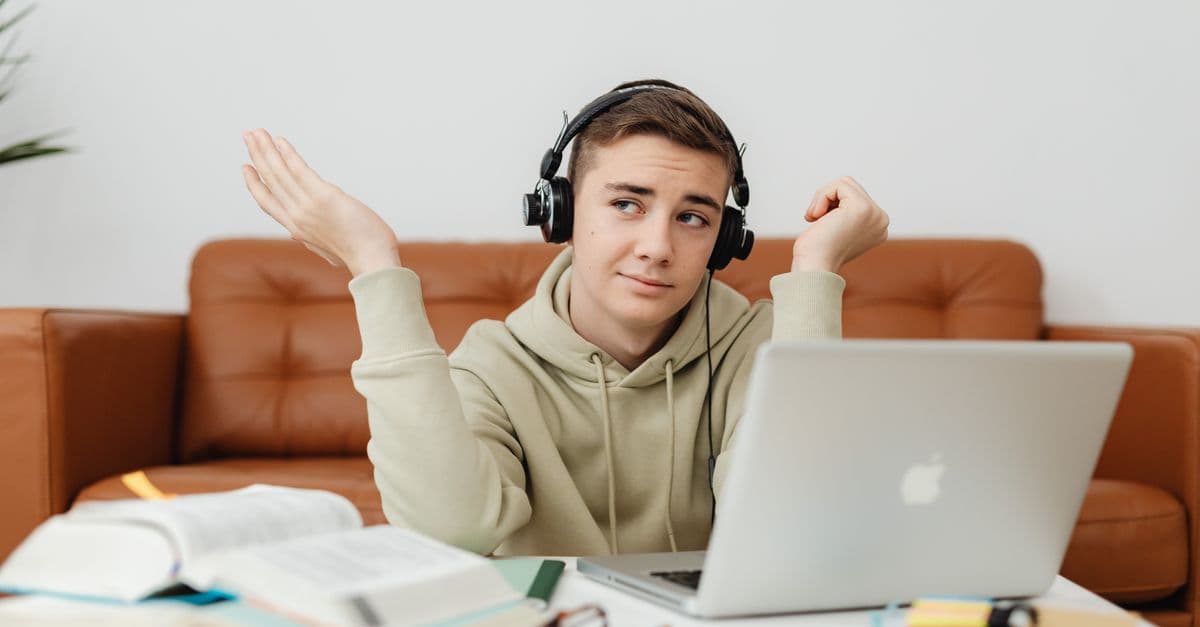 Aluno estudando inglês com fones e notebook — 8 músicas ideais para consolidar o inglês básico no nível A2
