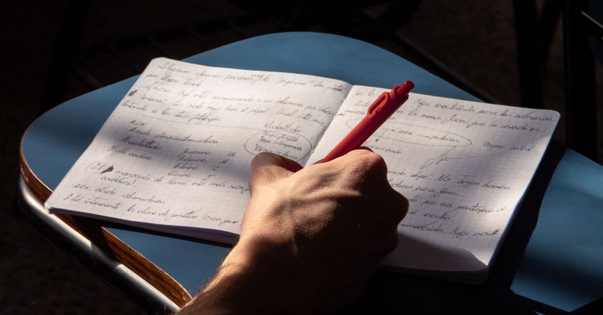 Estudante de inglês estudando com caderno — Cantar em inglês não é o mesmo que aprender inglês: o que fazer