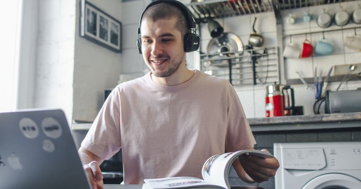 Aluno estudando inglês com fones e notebook — 6 músicas com letras poéticas que desafiam o nível B2