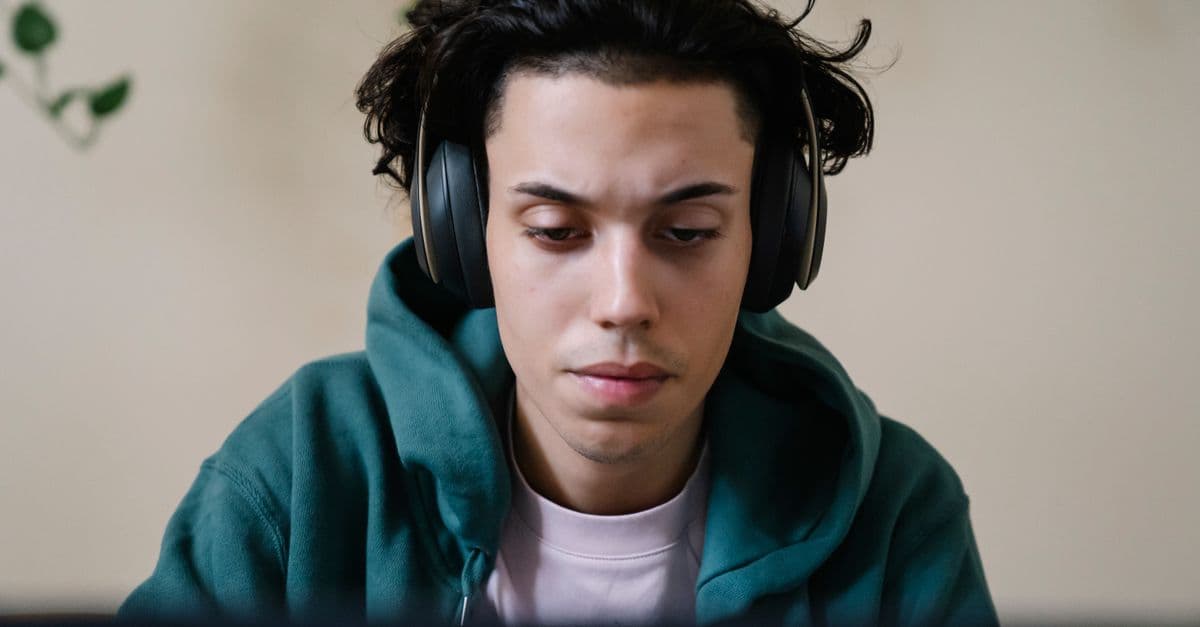Aluno estudando inglês com fones e notebook — Zero Conditional com Every Breath You Take